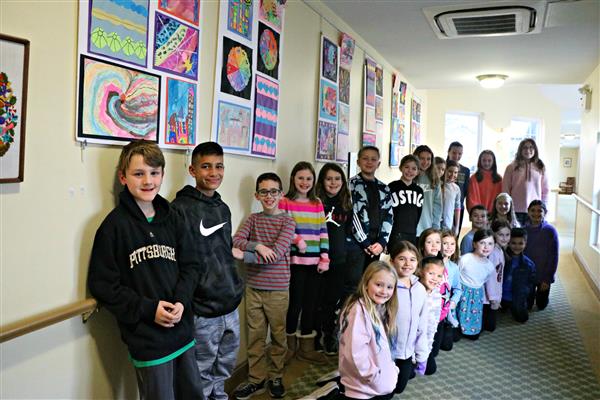 East Goshen Students pose in front of their artwork at Bellingham Retirement Community 